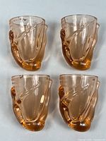 Four identical amber Berreteaga shot glasses front view
