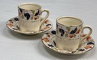 Two demitasse cups on saucers showing full sets and pattern