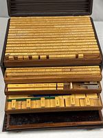 Cabinet with drawers open showing long rubber word stamps and compartments with smaller blocks