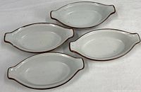 Top view of four oval stoneware dishes showing size and color