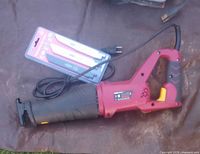 Red and black corded reciprocating saw with attached power cord and sealed blade pack