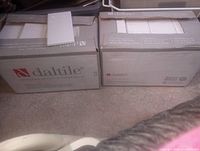 Two boxes of Daltile white ceramic wall tiles, opened to show tile edges and packaging condition