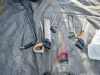 All eight saws laid on tarp showing variety and condition