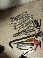 Group of mixed hand tools: wrenches, scissors, pliers, screwdriver set, level, crowbar, wood-handle punch