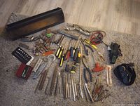 Full layout of assorted hand tools and toolbox holder on floor