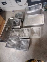 assorted stainless steel hotel pans with lids and clear plastic container
