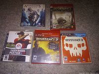 Front view of five PS3 game cases showing cover art and condition