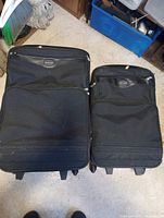 Front view of both Skyline suitcases showing size difference, exterior pockets, logo and wear