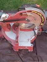 Tradesman red 10-inch corded miter saw on stand, blade in guard