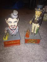 Uncle Sam and Stump Speaker cast iron mechanical banks on pedestals