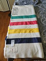 Folded Hudson's Bay wool blanket showing multicolor stripes and six point lines