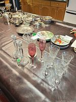 Group view of wine glasses, pink flutes, candleholders, surrounding items