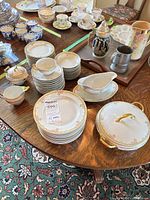 Overview of stacked plates, cups, saucers, covered dish, gravy boat
