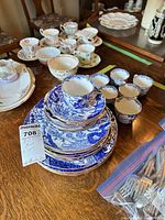 Stack of blue pattern plates, bowls, cups showing majority of lot
