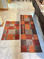 Runner and mat rugs laid side by side on tiled floor