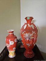 Both red ceramic vases front view on table