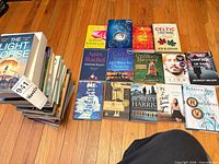Overall view of lot showing stacked and laid-out paperback books