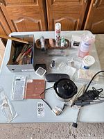 Overview of lot on table showing rotary tool, pickling pot, hand tools, dapping set, metal sheets, wax, flux