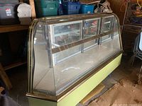 Front angled view showing curved glass, green base, stainless trim