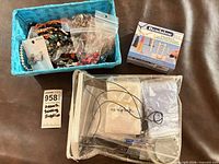 Overall contents: blue basket of beads, Beadalon tassel maker box, clear vinyl pouch with supplies