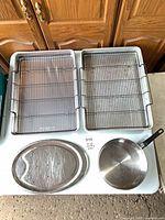 Top view of two roasting pans with racks, oval platter, and skillet