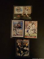 Four sleeved Deion Sanders trading cards arranged vertically