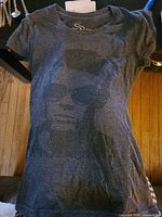 Front view of charcoal grey women’s T-shirt with James Dean portrait graphic