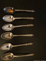 Six silver-plated teaspoons displayed bowl-up