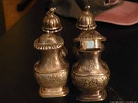 Front view of all four ornate shakers showing design and finish