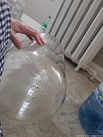 Side view of clear glass jug lying horizontally showing textured bottom pattern