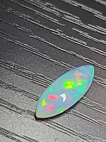 Marquise opal showing play-of-color on textured background