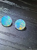 Two round faceted opals showing play of colour under lighting