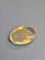 Top view of the oval jelly opal showing body colour and play of colour