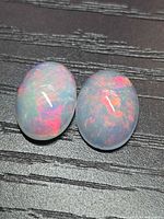 Two oval cabochon opals showing intense play of color