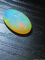 Top view of oval crystal opal showing play-of-colour