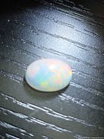 Top view of oval cabochon fire opal showing play-of-colour