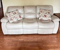 Front view of 3-seat leather sofa with pillows