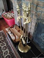 Full view of polished brass fireplace tool set on stand