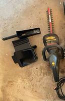 Yardworks hedge trimmer and black plastic chute attachment on floor