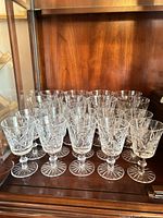 Cabinet shelf showing group of stemmed cut crystal glasses