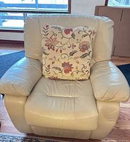 front view of beige leather recliner with floral pillow