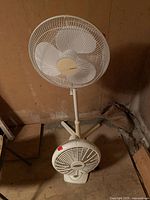 Full view showing Holmes pedestal fan and separate Lasko floor fan placed at base