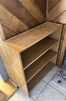 Front view of light oak bookcase showing three shelves and overall design