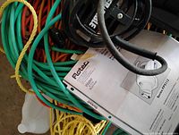 Close-up of Flotec manual over green hose and yellow wrap