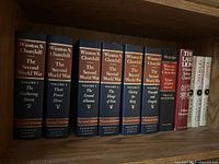 All 11 hardcover books aligned on shelf showing spines