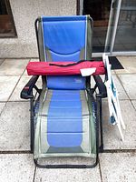 Blue Timber Ridge zero-gravity recliner with red carry bag and folded white/blue chair at side
