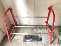 Overall view of metal tire rack and plastic ramp on floor