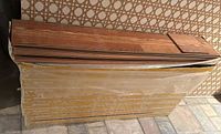 Stack of sealed Pergo flooring boxes with one opened to show planks