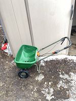 Side view of entire Scotts broadcast spreader outside shed