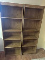 Front view of both oak-look bookshelves showing shelves and finish